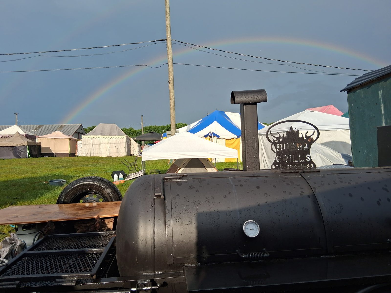 The Oak & Ash smoker parked among the tents of a Connecticut renaissance faire, a rainbow overhead